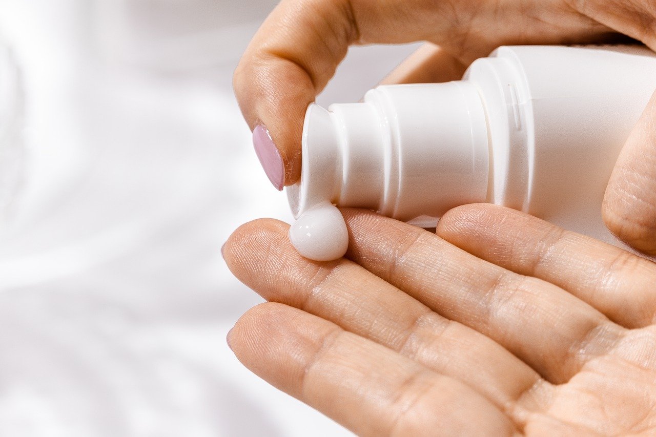 person moisturising their hands with cream