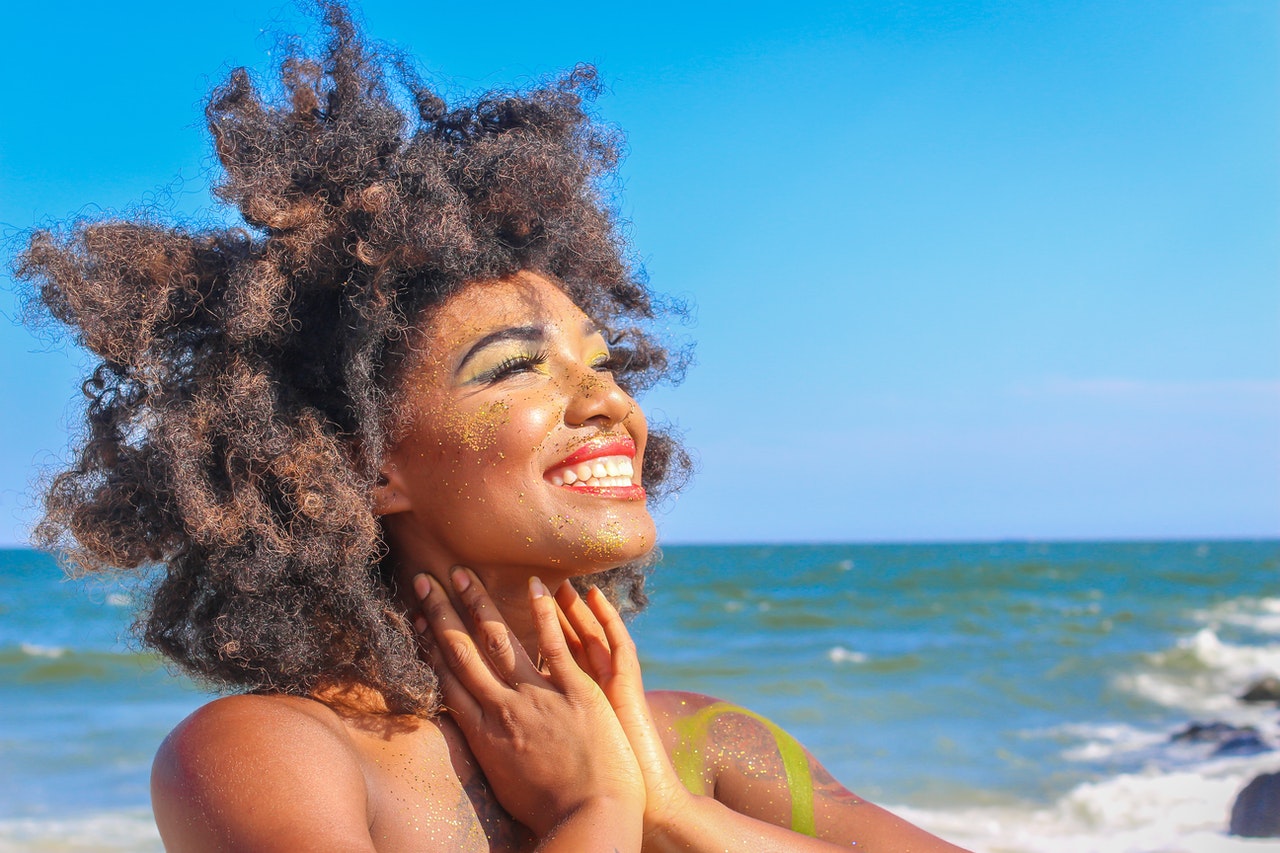 Woman with afro hair on the beach 